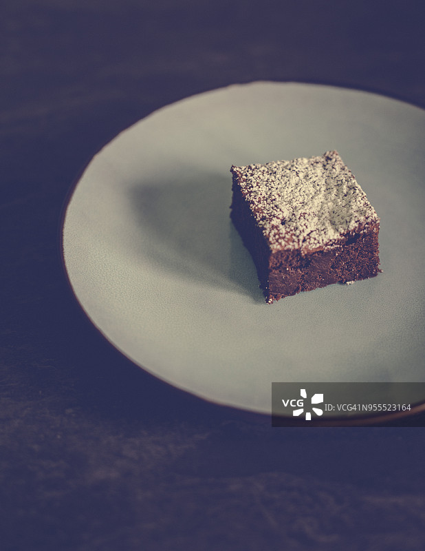 盘子上撒有糖粉的巧克力蛋糕切片图片素材