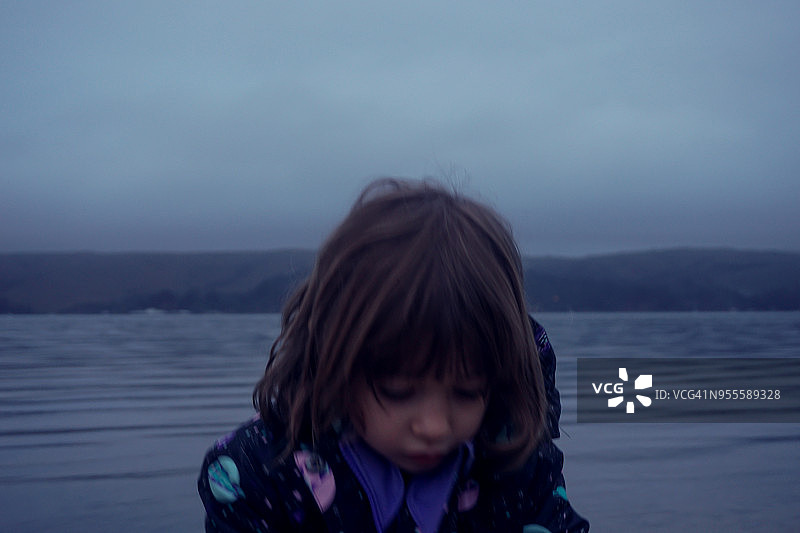 寒冷天气中海滩上的小女孩模糊照片图片素材