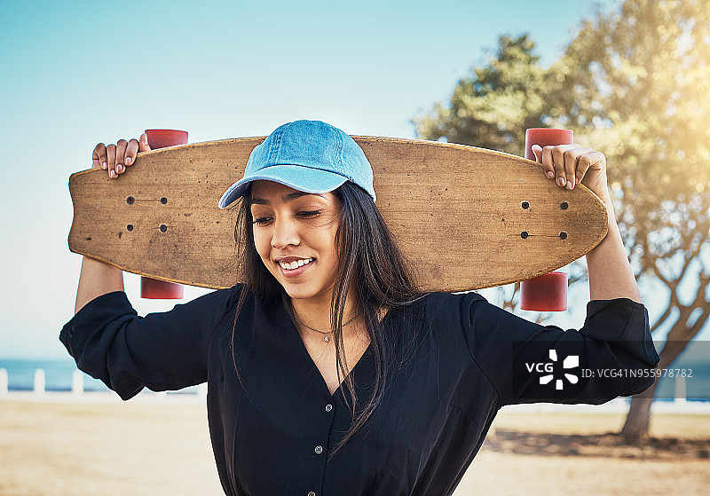 在海边玩滑板的年轻女子图片素材