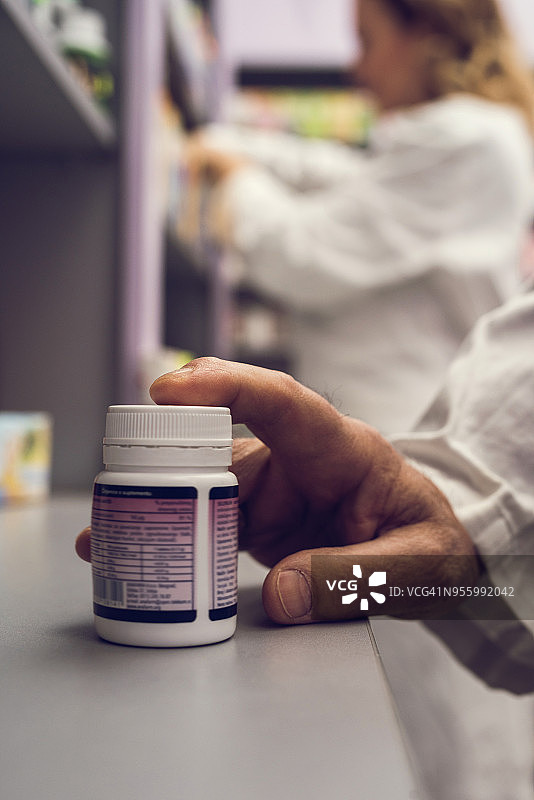手持药品容器特写图片素材