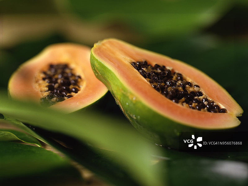 背景为绿叶的两半木瓜图片素材