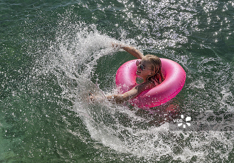 女孩在粉色充气游泳圈上玩水_斯托金岛_埃克苏马斯_巴哈马图片素材
