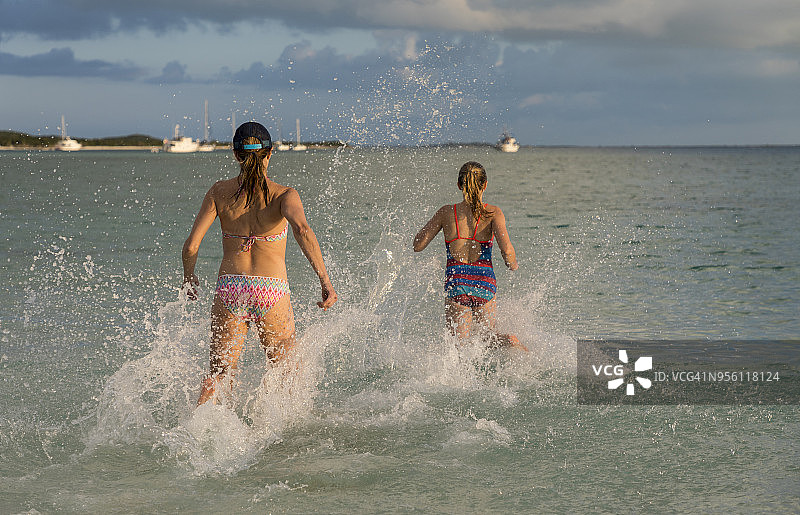母亲和女儿在巴哈马群岛埃克苏马斯群岛斯托金岛奔向水中图片素材