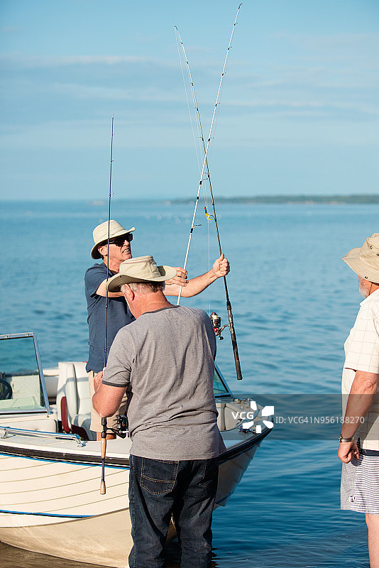 一起去钓鱼旅行的三个活跃的年长兄弟图片素材
