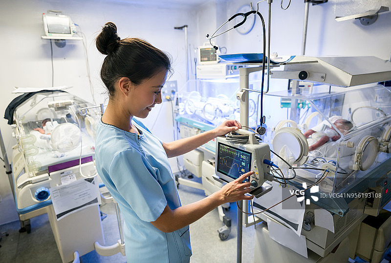 拉丁美洲护士在新生儿重症监护室检查早产儿的监护仪图片素材