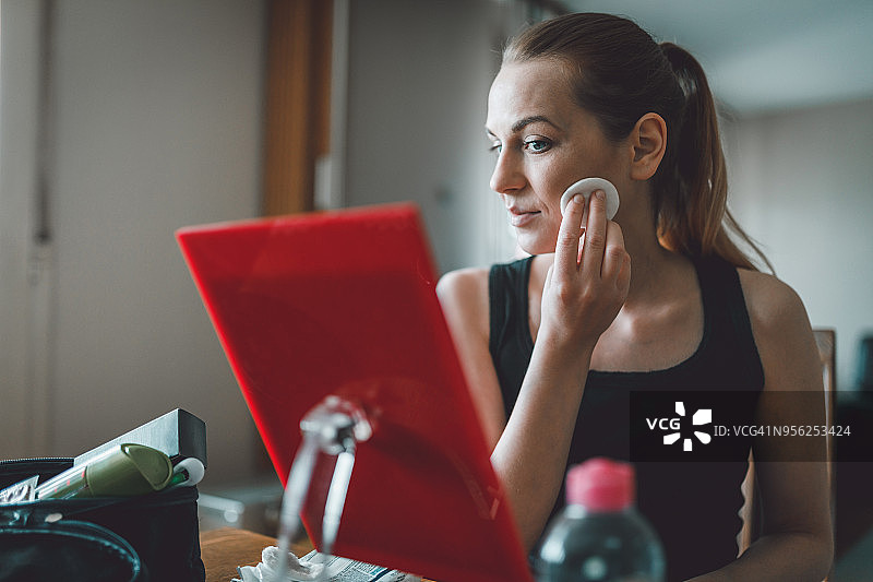 照镜子用化妆棉卸妆的漂亮女人图片素材