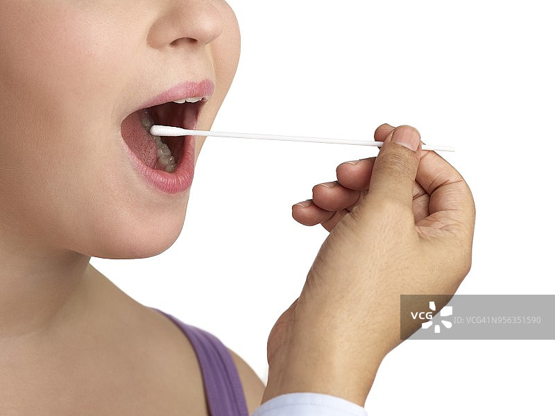 医生为一名妇女做口腔拭子采样图片素材