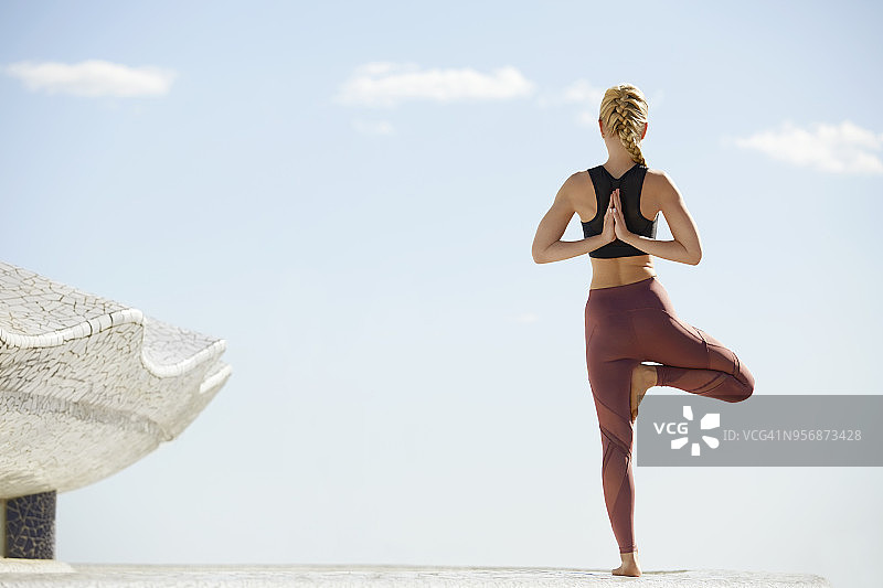 女子在露台上练习树式瑜伽图片素材