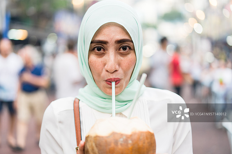 享受椰子汁的穆斯林女人图片素材