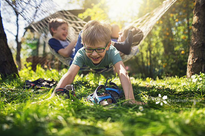 孩子们在后院的吊床上玩耍图片素材