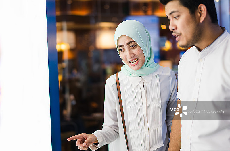 穆斯林夫妇在橱窗前购物图片素材