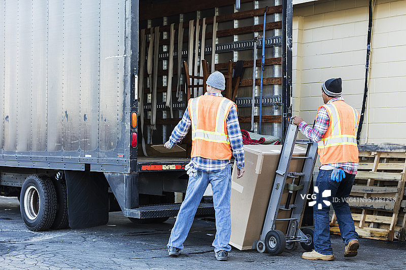 两名工人用卡车搬运大箱子图片素材