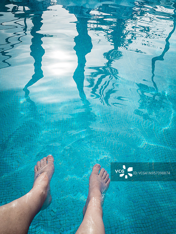 人脚在游泳池水中晃荡的视角图片素材