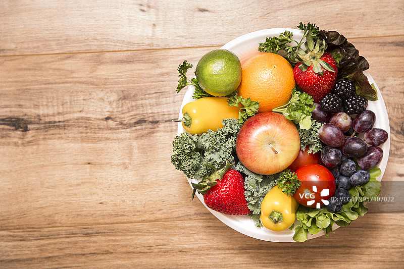 木质背景碗里的健康水果和蔬菜图片素材