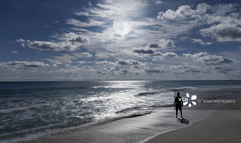 男人在海滩上欣赏满月和大海_埃克苏马群岛_巴哈马图片素材