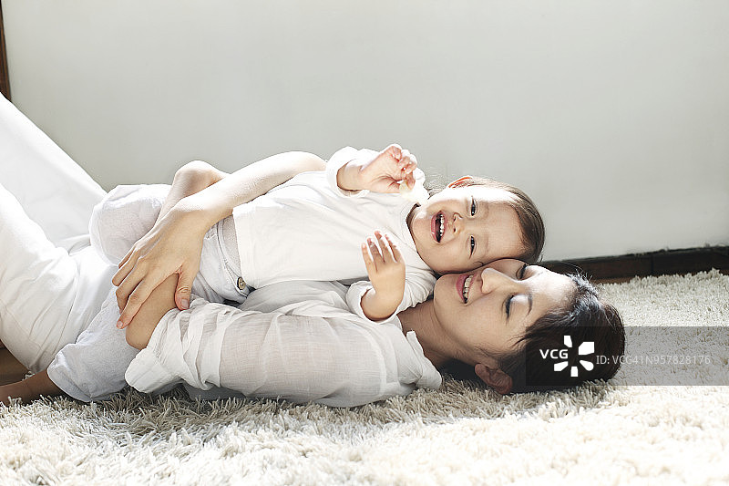 母亲和宝宝躺在地板上图片素材