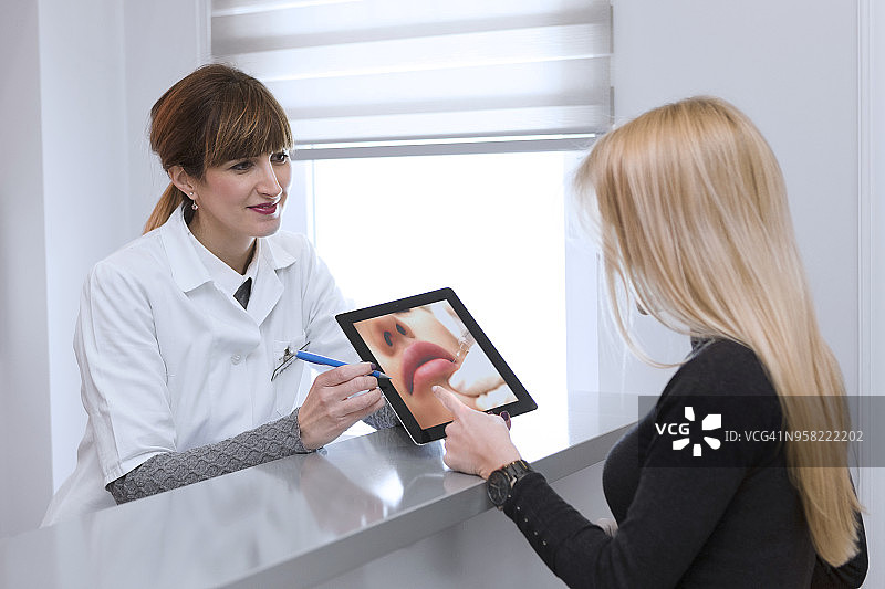 医生用平板电脑向病人讲解病情图片素材