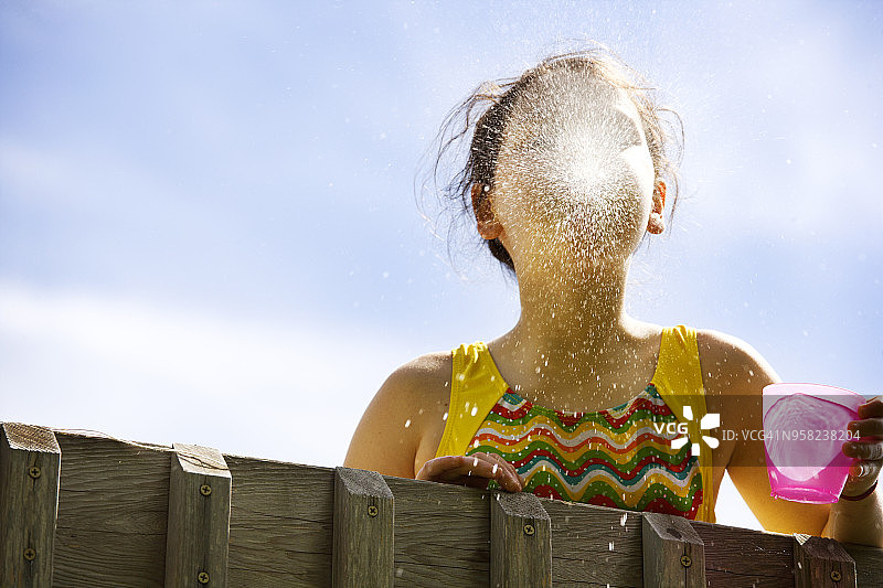 女孩对着天空吐水的仰视角度照片图片素材