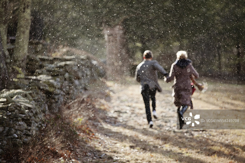 冬季情侣在田野上奔跑的背影图片素材