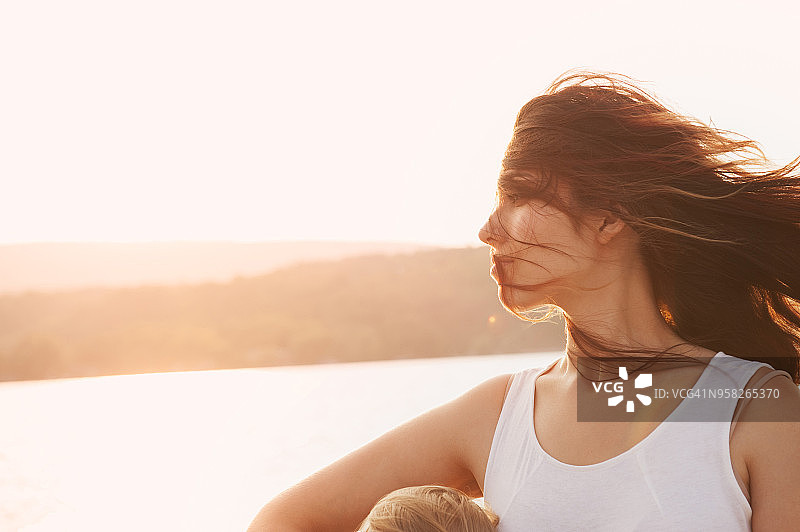 日落时分，湖边头发蓬乱的女人图片素材