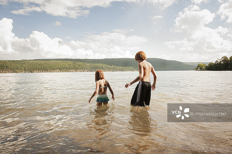 兄妹在湖边仰望天空的背影图片素材