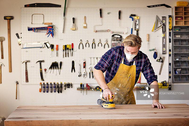 男木匠在工坊里用设备处理木材图片素材