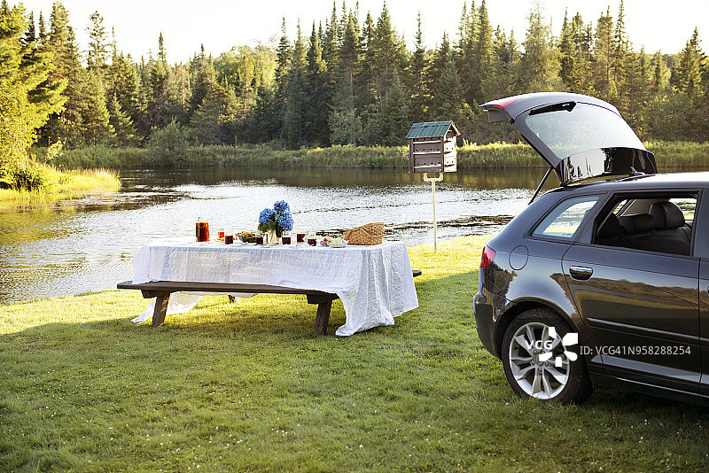 停在草地野餐桌旁的汽车图片素材