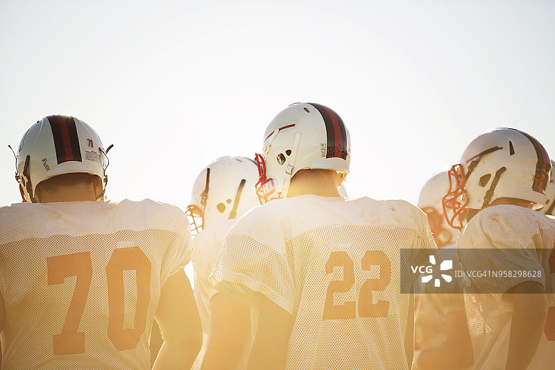 阳光明媚的日子里，足球运动员在天空下的背影图片素材