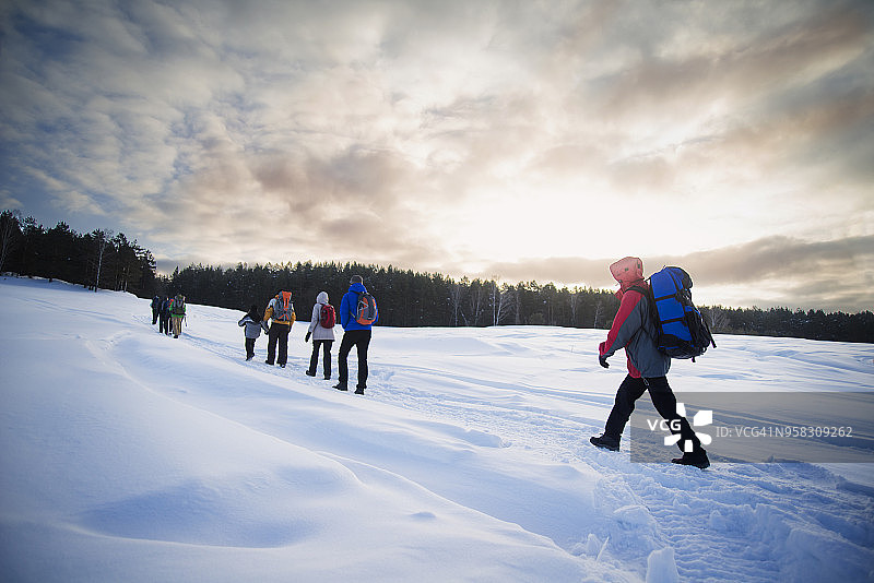 朋友雪地徒步多云天空图片素材
