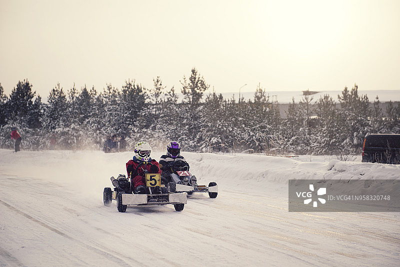 男孩们在雪地上玩卡丁车图片素材