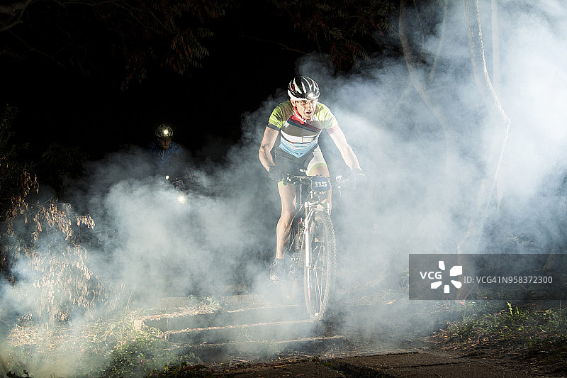 夜晚在道路上骑自行车的男子图片素材