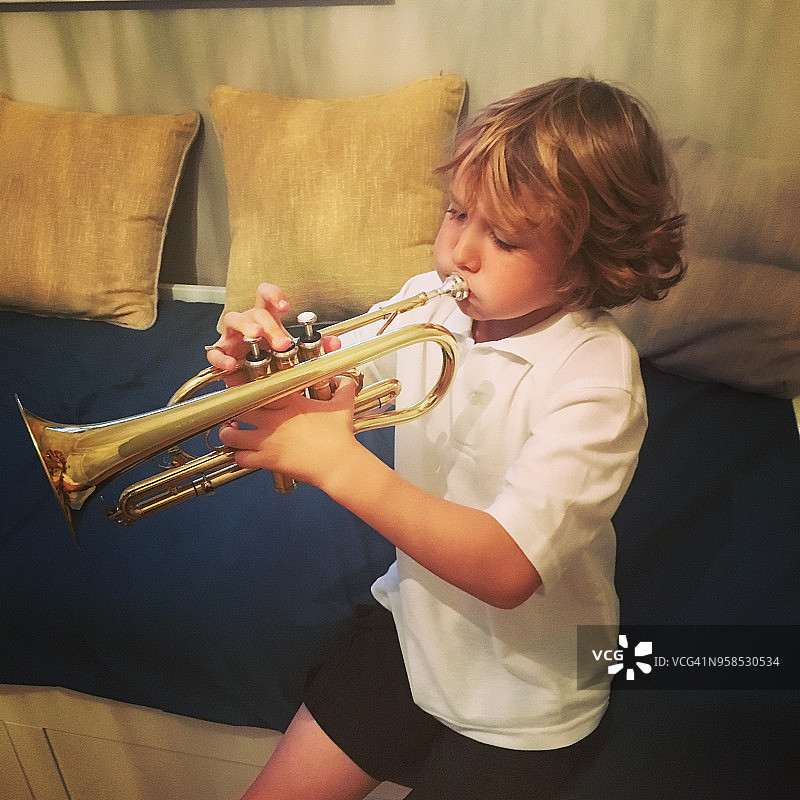 演奏短号的7岁男孩图片素材
