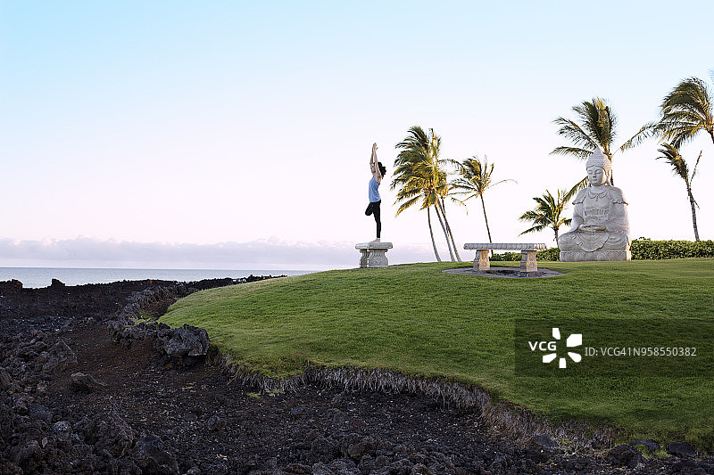 女人在长凳上对着佛像锻炼的侧面图片素材