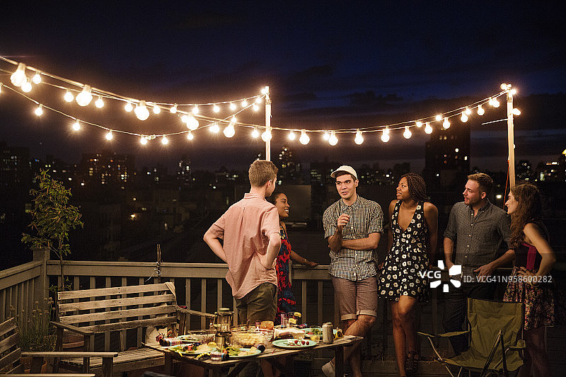 朋友站在建筑露台的栏杆旁聊天图片素材