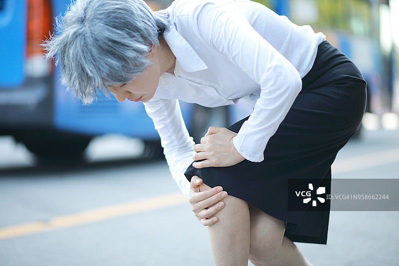 年长的女人在户外膝盖疼痛图片素材