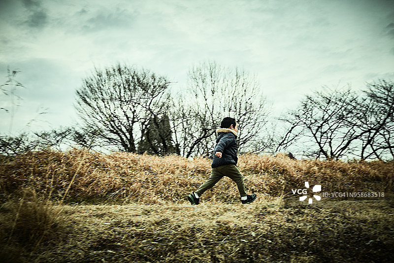 男孩独自在河岸边奔跑图片素材