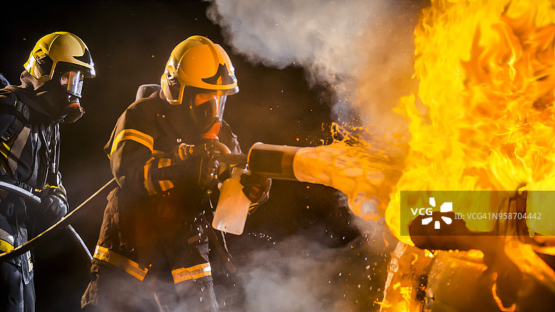 消防员用泡沫灭火剂扑灭燃烧的汽车图片素材