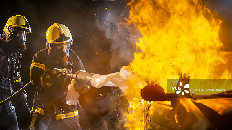 消防员用泡沫灭火剂扑灭燃烧的汽车图片素材