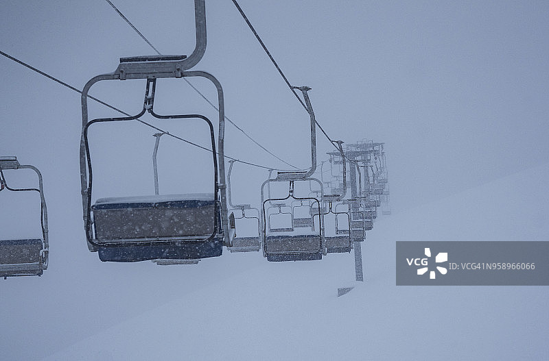 暴风雪中缆车上的空椅子图片素材