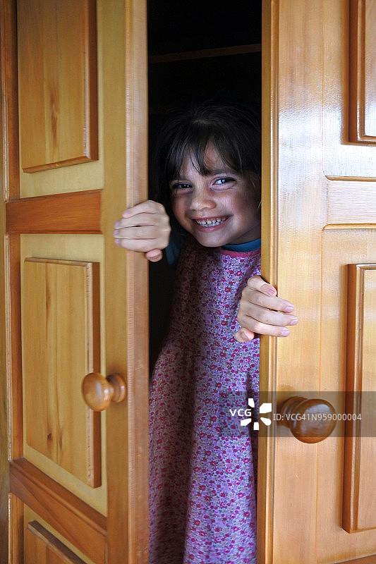 小女孩惊讶地发现紧闭的门后有什么图片素材