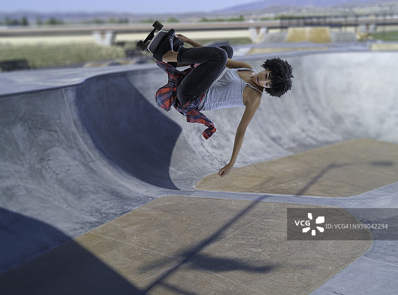 在滑板上跳跃的年轻女性图片素材