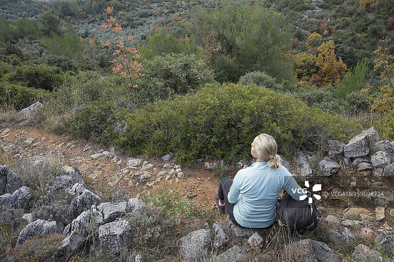 佩戴护膝的徒步登山者在小路上休息图片素材
