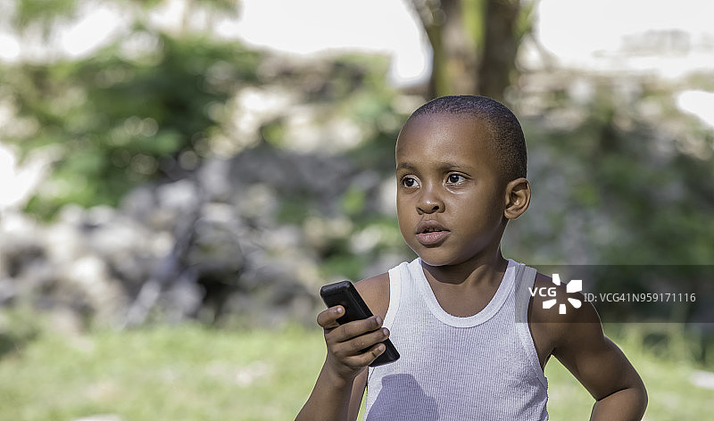 拿着手机的牙买加男孩图片素材