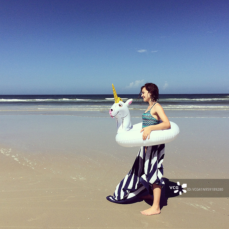 拿着独角兽内胎游泳圈的女孩图片素材