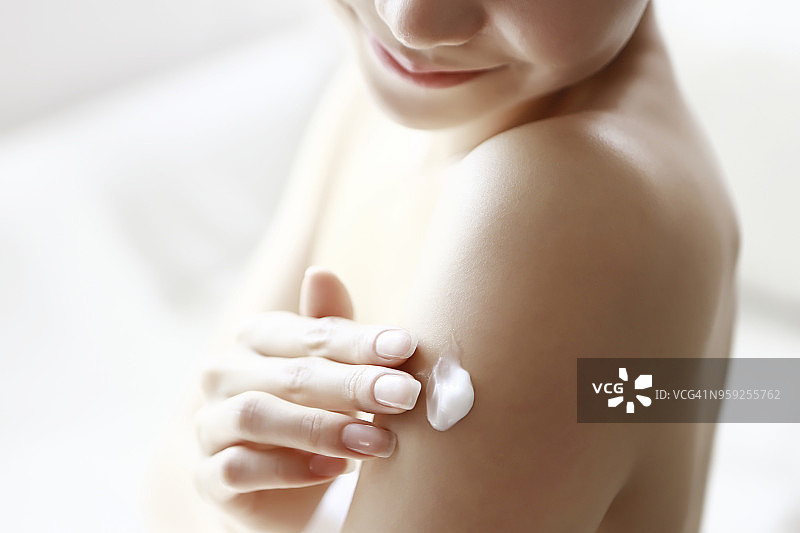 女人在手臂上涂抹润肤露图片素材