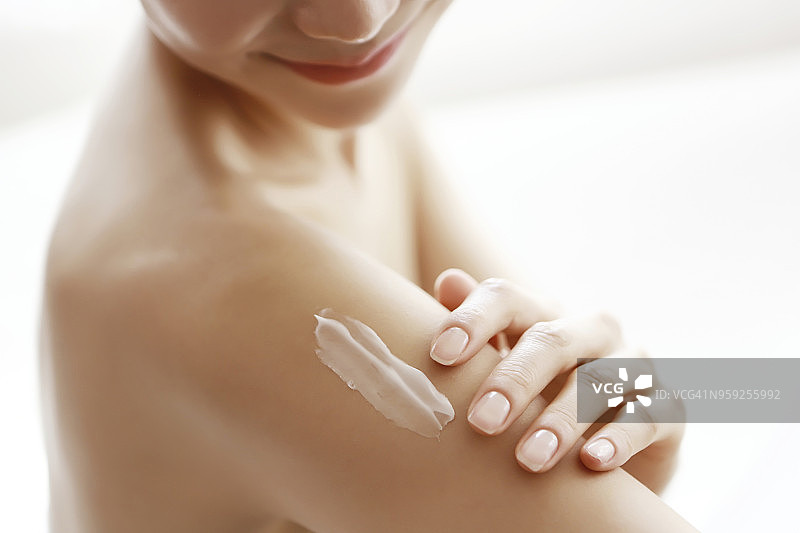 女人在手臂上涂抹润肤露图片素材