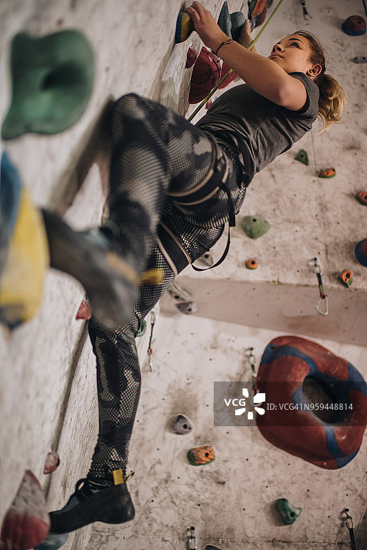 女运动员在抱石健身房练习攀岩图片素材