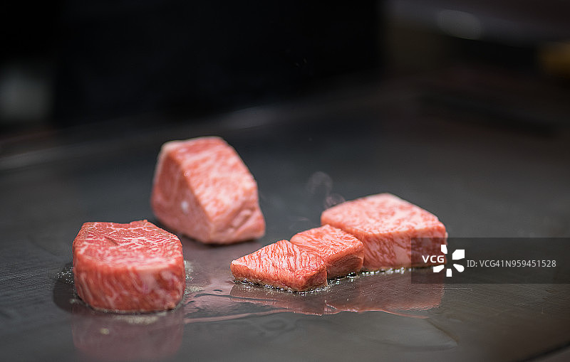 日式铁板烧：厨师为客人烹饪牛肉图片素材
