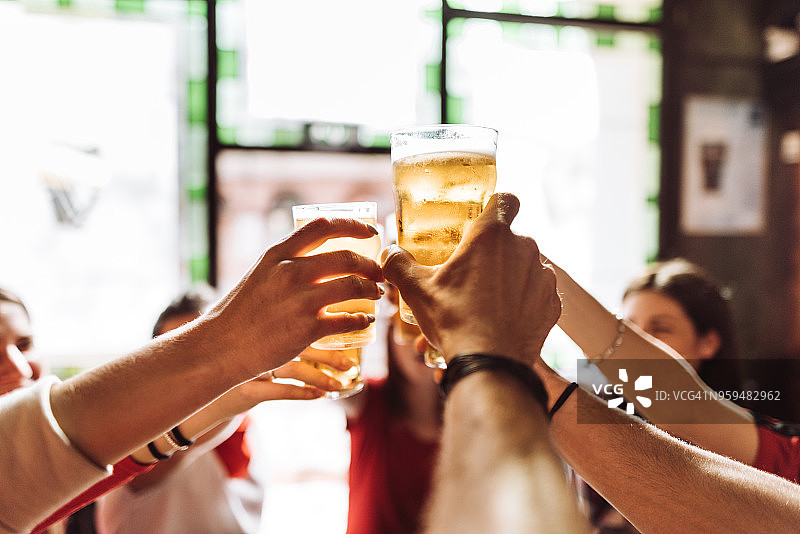 朋友们在酒吧里敬啤酒图片素材
