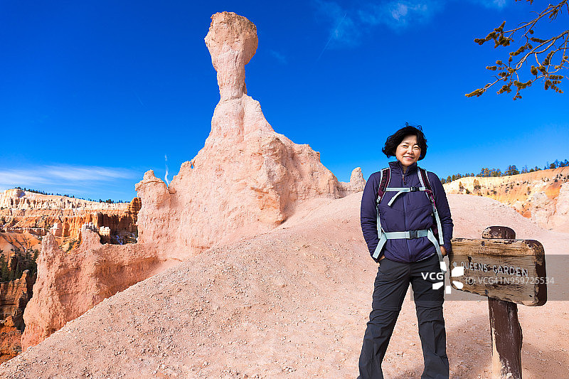 中年妇女在布莱斯峡谷国家公园的女王花园小径上徒步旅行图片素材
